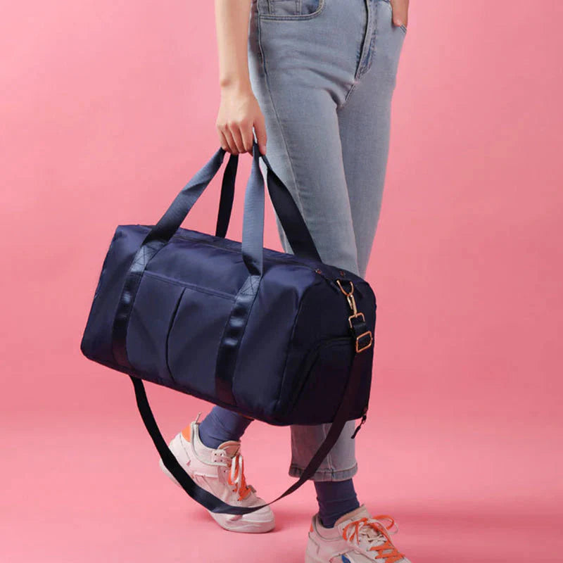HealthyRealLife navy waterproof fitness duffel bag carried by person with adjustable shoulder strap